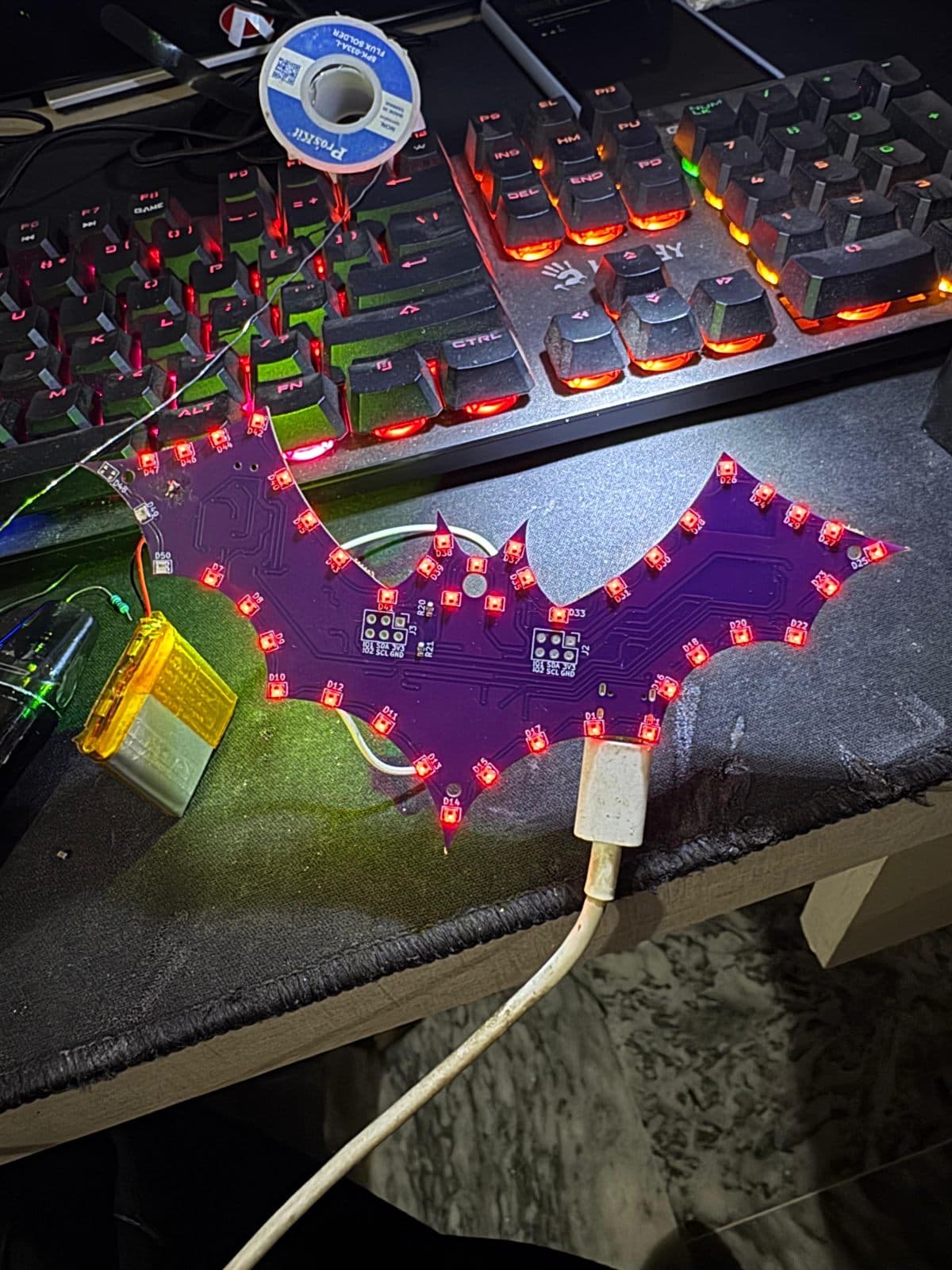 The badge illuminated while connected to USB-C, with the LiPo cell attached, demonstrating power-path switching between USB and battery