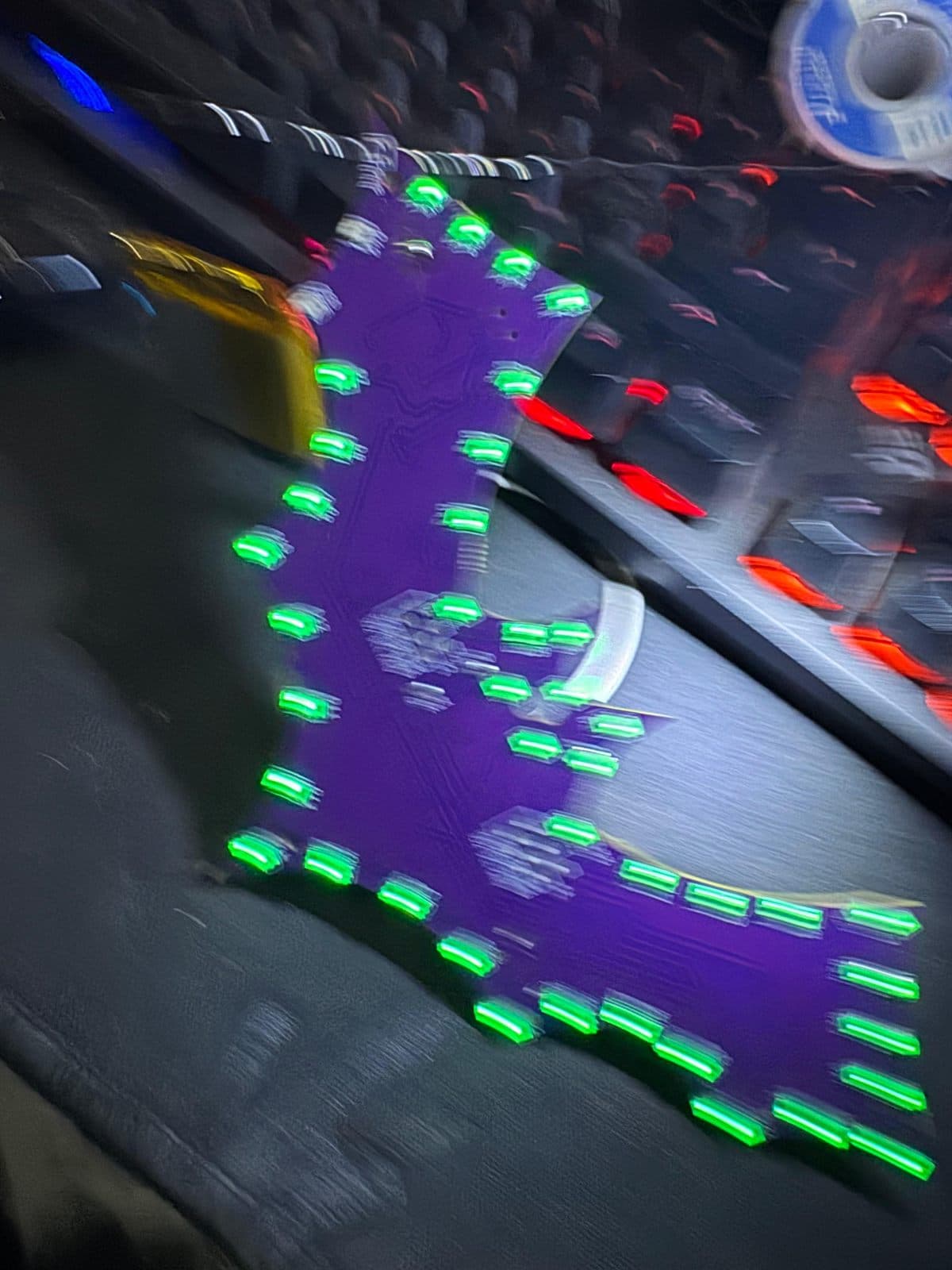 The badge running an animated colour sequence, LEDs lit green